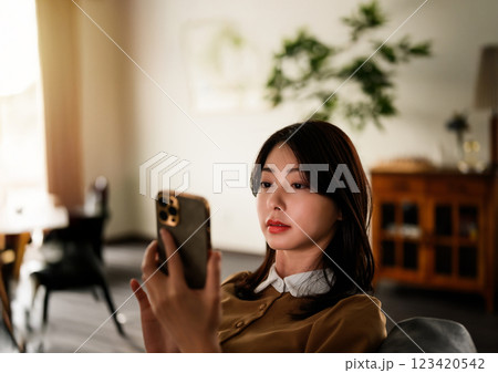 スマートフォンを見つめる女性の上半身 123420542