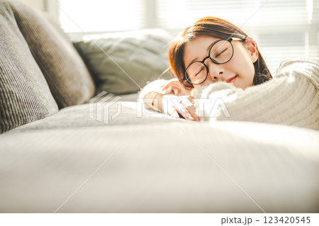 ソファでくつろぐ眼鏡の女性 ソファでくつろぐ眼鏡の女性 123420545
