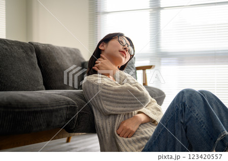 首を触る眼鏡の女性 123420557