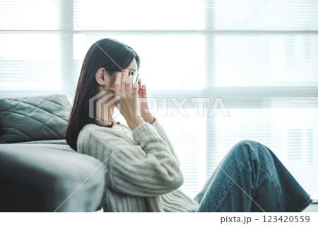 ソファでリラックスするメガネの女性 123420559