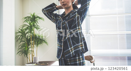 朝の光の中で髪をまとめる女性 朝の光の中で髪をまとめる女性 123420561