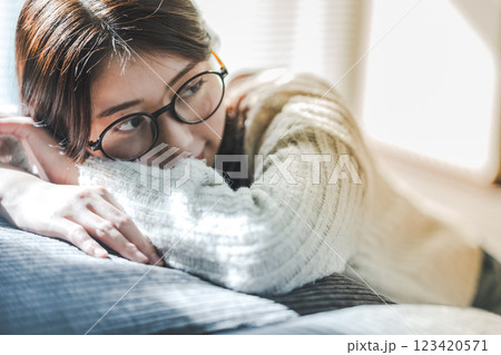 日差しを浴びながらソファでくつろぐ女性 日差しを浴びながらソファでくつろぐ女性 123420571