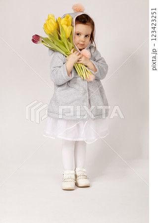 Thoughtful Toddler in Bunny Costume Holding a Bouquet of Yellow and Burgundy Tulips Thoughtful Toddler in Bunny Costume Holding a Bouquet of Yellow and Burgundy Tulips 123423251