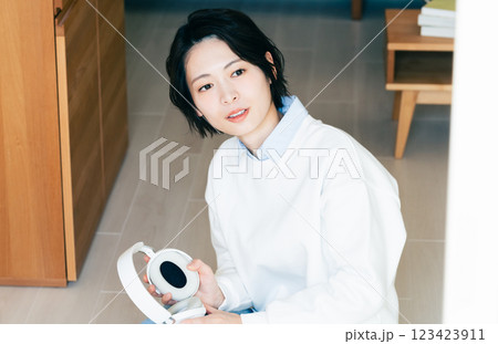窓辺でヘッドフォンを持つ女性 窓辺でヘッドフォンを持つ女性 123423911