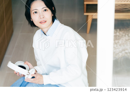 窓辺でヘッドフォンを持つ女性 123423914