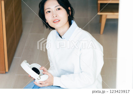 窓辺でヘッドフォンを持つ女性 窓辺でヘッドフォンを持つ女性 123423917