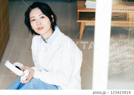窓辺でヘッドフォンを持つ女性 123423919