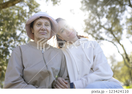 Senior woman and daughter enjoying time together in park on sunny day 123424110