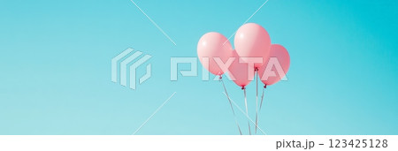 Four pink balloons are tied together, floating against a vibrant clear blue sky, symbolizing love, celebration, and the joy of valentine's day and the arrival of spring 123425128