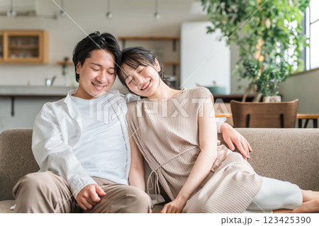 家のリビングでソファーに座る若いアジア人夫婦 123425390