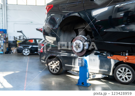 Car service workshop with cars on a column lifts Car service workshop with cars on a column lifts 123428959
