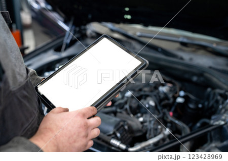 Serviceman with tablet checks car software in car service Serviceman with tablet checks car software in car service 123428969