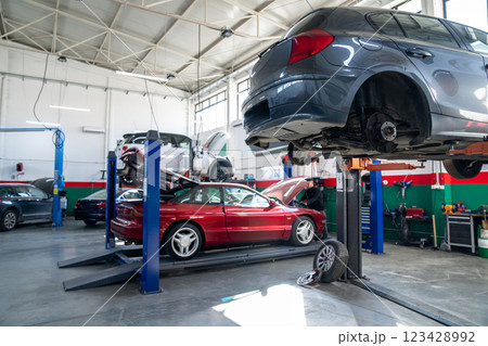 Car service workshop with cars on a column lifts Car service workshop with cars on a column lifts 123428992