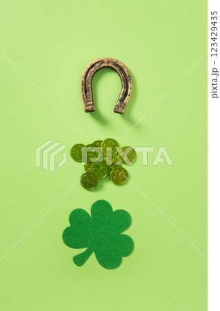 St. Patrick's day creative minimal composition with clover leaf, green coins and horseshoe on light green background. View from above. 123429435