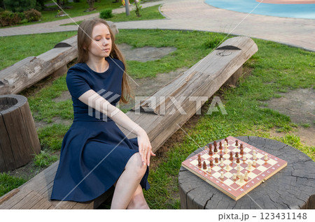 Caucasian woman playing chess outdoors. 123431148
