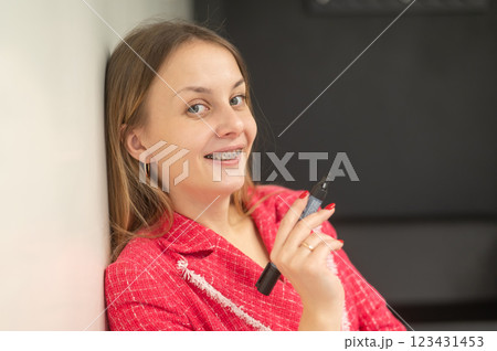 Caucasian woman with braces on teeth standing with marker at white board.  123431453