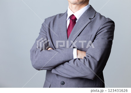 グレーのスーツを着て腕組みをするミドル男性ビジネスマン グレーのスーツを着て腕組みをするミドル男性ビジネスマン 123431626