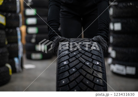 Mechanic keeps new studded car tires in garage.  123431630