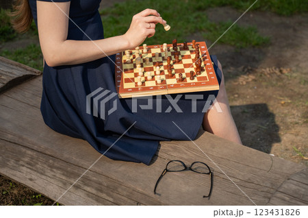 Caucasian woman playing chess outdoors. Caucasian woman playing chess outdoors. 123431826