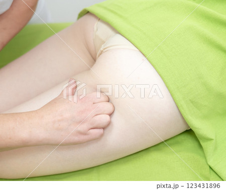 Anti-cellulite manual massage of thighs. Anti-cellulite manual massage of thighs. 123431896