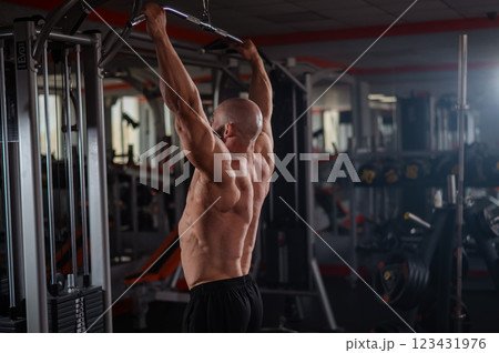 Caucasian man doing lat pull-downs on a machine. Caucasian man doing lat pull-downs on a machine. 123431976