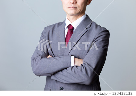 グレーのスーツを着て腕組みをするミドル男性ビジネスマン 123432132