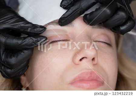 The master lays down the roller before the eyelash lamination procedure.  123432219