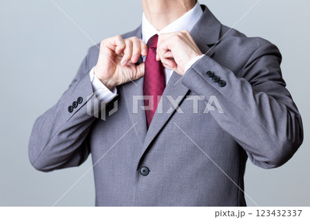 グレーのスーツを着てネクタイを直すミドル男性ビジネスマン 123432337