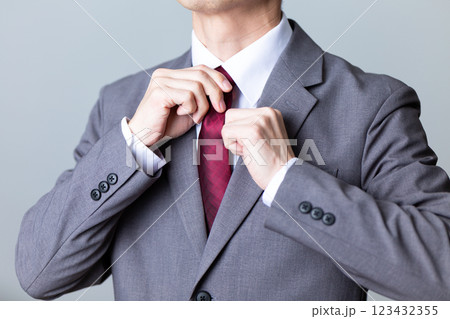 グレーのスーツを着てネクタイを直すミドル男性ビジネスマン 123432355