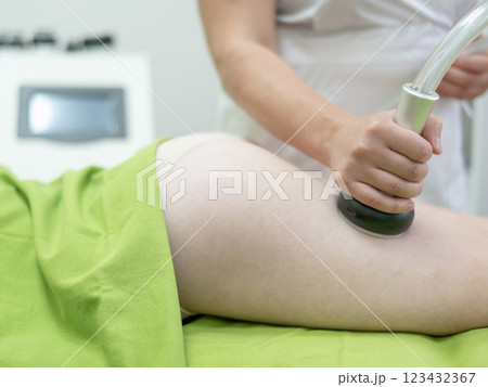 Caucasian woman on hardware anti-cellulite massage. Thigh cavitation procedure. Caucasian woman on hardware anti-cellulite massage. Thigh cavitation procedure. 123432367