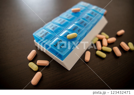Blue tablet on a black table with scattered green and pink pills Blue tablet on a black table with scattered green and pink pills 123432471