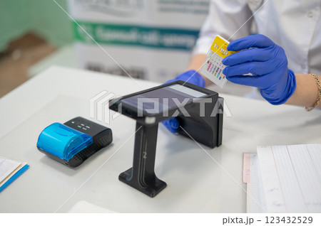 A narcologist tests urine for drugs using an electronic device.  123432529