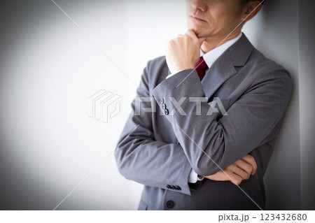 グレーのスーツを着て悩むミドル男性ビジネスマン グレーのスーツを着て悩むミドル男性ビジネスマン 123432680