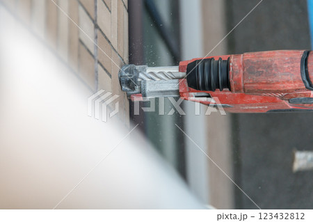 【マンション大規模修繕工事　足場を作る作業員ドリル】 123432812