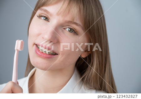 Portrait of a caucasian woman with braces on her teeth holding a toothbrush. Portrait of a caucasian woman with braces on her teeth holding a toothbrush. 123432827