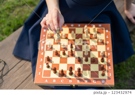 Caucasian woman playing chess outdoors. 123432974
