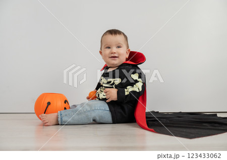 Cute caucasian boy in dracula halloween costume holding candy basket on white background. Cute caucasian boy in dracula halloween costume holding candy basket on white background. 123433062