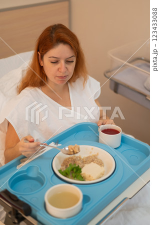 Caucasian woman eating on hospital bed. Caucasian woman eating on hospital bed. 123433088