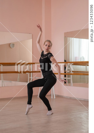 Caucasian blonde woman is practicing ballet in class. Rehearsal. Vertical photo. Caucasian blonde woman is practicing ballet in class. Rehearsal. Vertical photo. 123433096