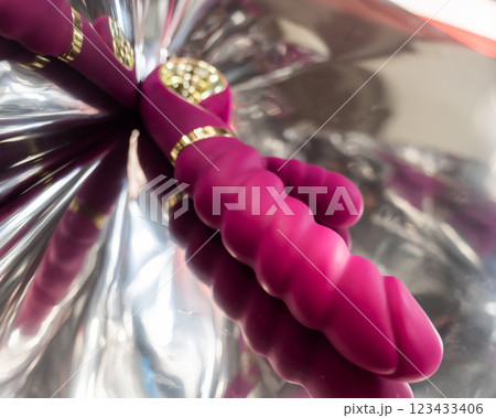 Sex toy on a metal background in the reflections of light.  123433406