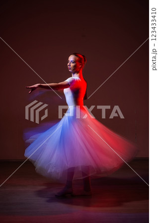 Caucasian woman dancing classical dance in tutu . Long exposure photo. Caucasian woman dancing classical dance in tutu . Long exposure photo. 123433410