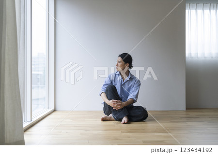 フローリングの床に座るアラフォーの男性 123434192