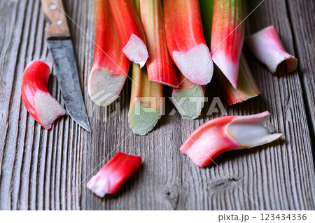 Ripe pink rhubarb stalks with knife on a wooden table 123434336