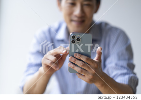 スマートフォンを操作するアラフォーの男性の手元 スマートフォンを操作するアラフォーの男性の手元 123434355
