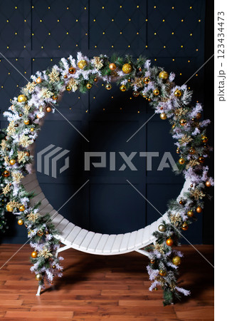 round bench with christmas branches on blue background. new year photo zone 123434473