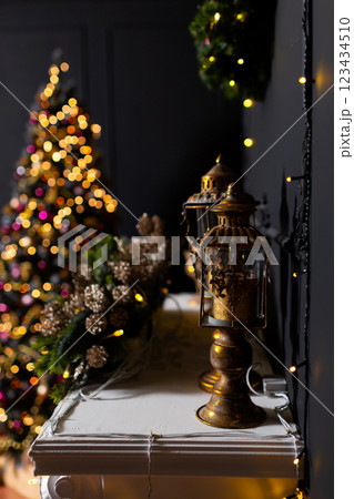 Christmas candlesticks on a white shelf in a room against a black wall. New Year's decoration Christmas candlesticks on a white shelf in a room against a black wall. New Year's decoration 123434510