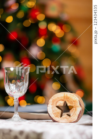 New Year's table setting in a photo studio. Plates with glasses on a Christmas tablecloth 123434535
