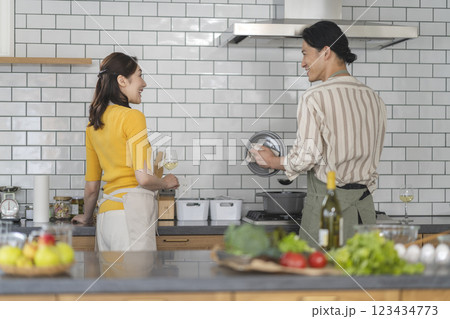 キッチンに立つアラフォーのカップル 料理をする男性 キッチンに立つアラフォーのカップル 料理をする男性 123434773