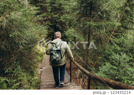 Young 30s man hiking in nature. Travel, adventure. Concept of an active lifestyle. The National park Adrspach Teplice rocks. High quality photo. Full body, back view. Young 30s man hiking in nature. Travel, adventure. Concept of an active lifestyle. The National park Adrspach Teplice rocks. High quality photo. Full body, back view. 123435214