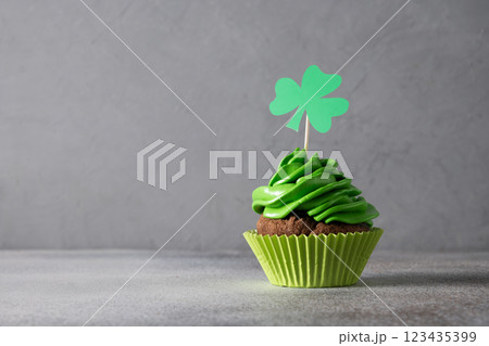 St. Patrick's Day cupcake with green whipped cream decorated clover on gray background. Copy space. Close up. Festive food. St. Patrick's Day cupcake with green whipped cream decorated clover on gray background. Copy space. Close up. Festive food. 123435399